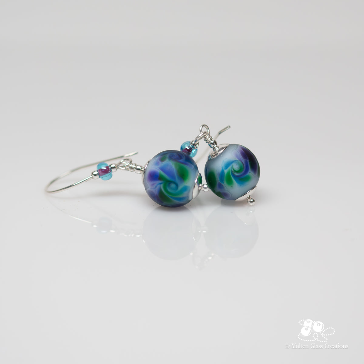 Lavender Frost Earrings - side view showing frosted lavender lampwork glass beads with purple and green swirls on sterling silver earwires